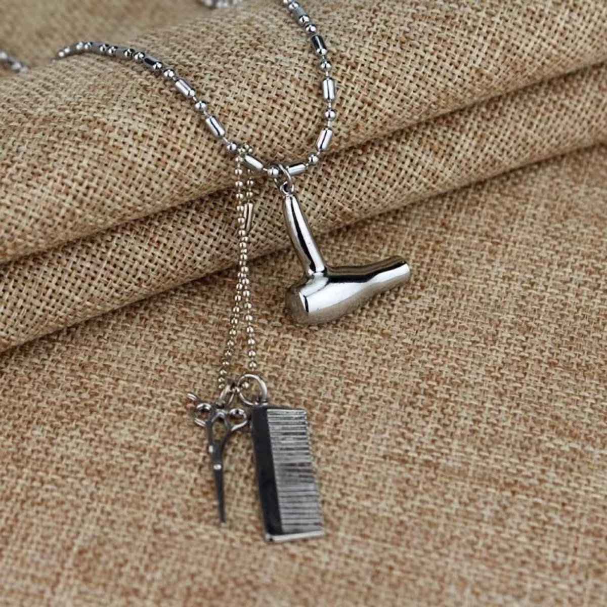 Charm de barbearia em colar metálico – tesoura, pente, secador